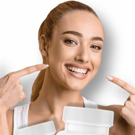 Smiling woman pointing at teeth while holding ProDentim bottles